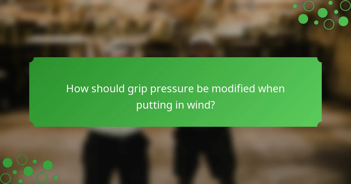 How should grip pressure be modified when putting in wind?